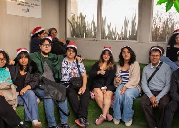 Un grupo de asistentes sentados en el césped del campus