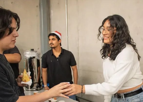 Dos asistentes sirven la chocolatada desde el dispensador
