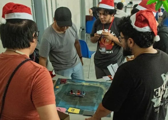 Asistentes reunidos alrededor de una mesa de juegos