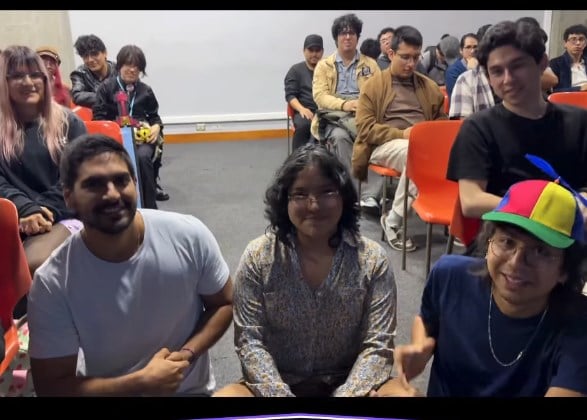 Asistentes al concurso sentados entre el público, sonriendo a cámara